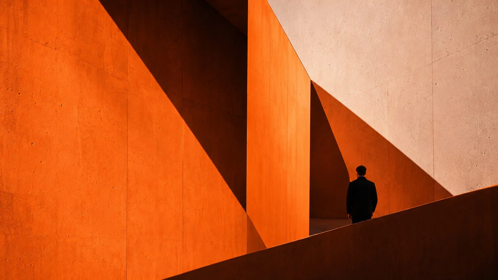 Arquitectura de hormigón naranja con una persona al final del paso