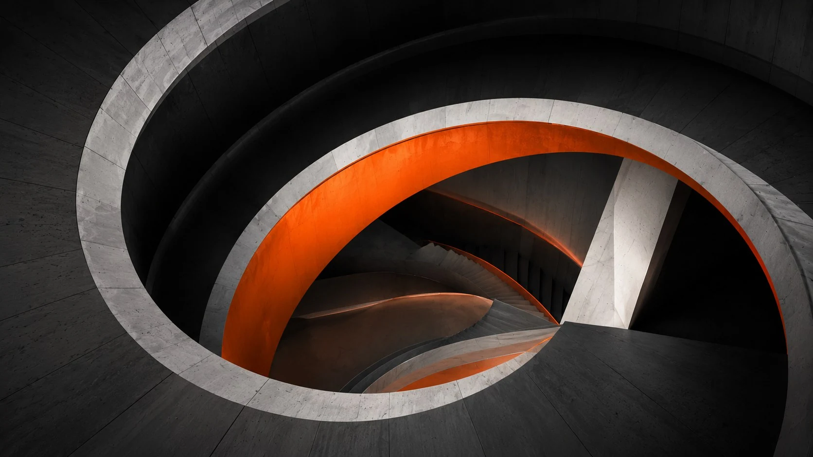Escalera circular de hormigón con el interior en naranja
